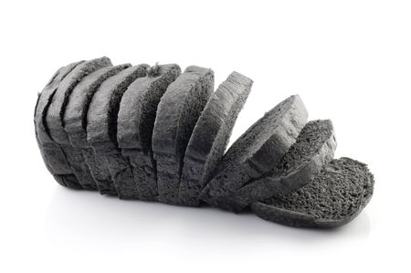 The cut loaf of black charcoal bread isolated on whiteの写真素材