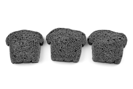 Three slices black charcoal bread on white backgroundの写真素材