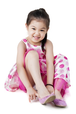 Little girl putting on her shoeの写真素材