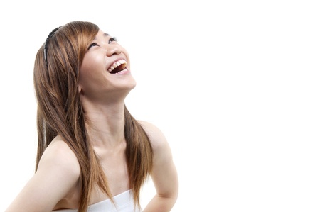 Laughing Asian woman looking up on white backgroundの写真素材