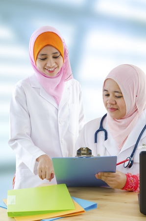 Two female Muslim doctor discussing on medical reportの写真素材