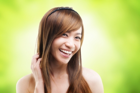 Cheerful Asian female combing her hair using fingerの写真素材