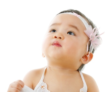 Curious asian baby girl looking up, isolated on white backgroundの写真素材