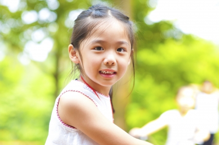 Little Asian girl riding bike outdoorの写真素材