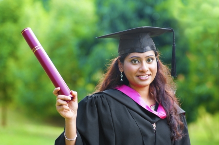 Smiling Young Asian Indian female student showing her certificateの写真素材