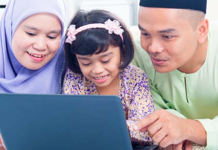 Southeast Asian family browsing internet at home. Muslim family living lifestyleの写真素材