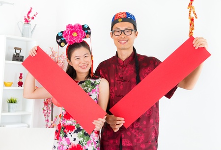 Happy Chinese New Year. Asian people Showing red spring couplets, indoor home.の写真素材