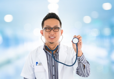 Southeast Asian medical doctor with stethoscope in hand, standing in hospitalの写真素材