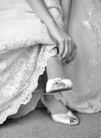 The bride is putting on her shoes for the wedding day.の写真素材