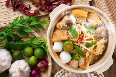 Hot and spicy Singaporean Curry Noodle or laksa  mee with hot steam in clay pot, decoration setup, serve with chopsticks. Singapore cuisine.の写真素材