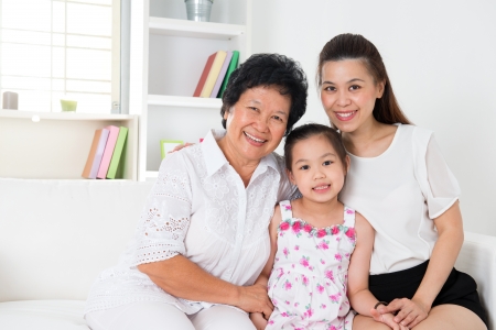 grandparent, parent and grandchild sitting on sofa smilingの写真素材