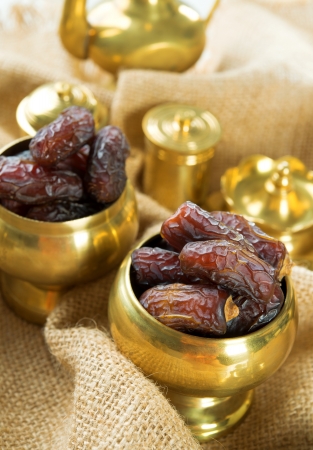 Dates. Dried date palm fruits or kurma, ramadan food which eaten in fasting month. Pile of fresh dried date fruits in golden metal bowl.の写真素材