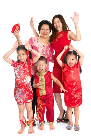 Group of happy  smiling multi generations Asian Chinese family wishing you a happy Chinese New Year, with traditional Cheongsam standing isolated on white background.の写真素材