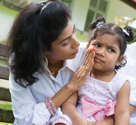 Indian family outdoor. Parent is comforting her crying child.の写真素材