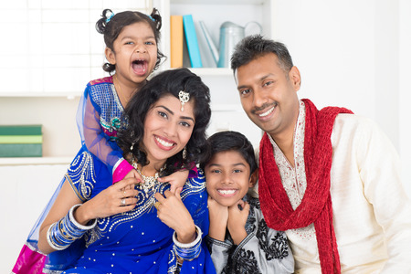Happy smiling Indian family at home. Living lifestyle of parents and children in their traditional dress in modern house.の写真素材