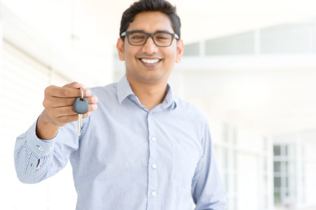 Young Asian Indian estate agent or salesman showing a keyの写真素材