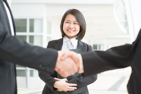 Business deal, Asian businessmen handshaking. Focus on assistant or secretary. の写真素材