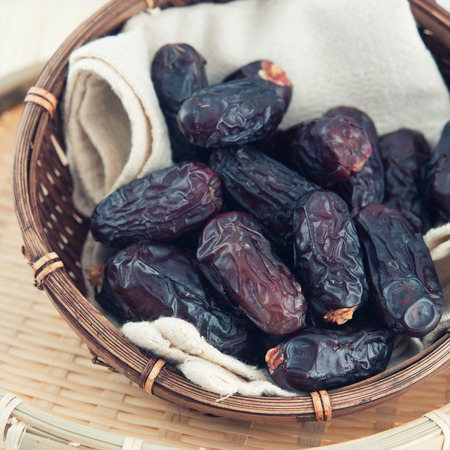 Dates fruit or kurma. Pile of fresh dried date fruits in a basket.の写真素材