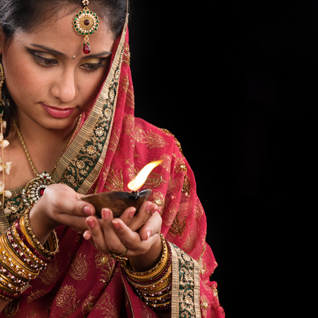 Beautiful Indian woman hands holding diya oil lamp, celebrating diwali festive of lights,...