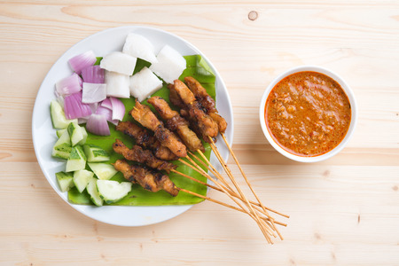Overhead view delicious chicken satay on wooden dining table, one of famous Malaysian local dishes.の写真素材