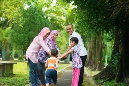 Happy family playing at outdoor garden park. Southeast Asian people living lifestyle.の写真素材