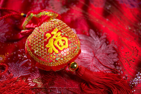 Chinese new year decorations, lucky bag on red background. The Chinese character means "lucky", not a logo or copyright.の写真素材