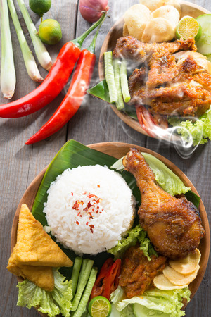 Popular delicious Indonesian local food nasi ayam penyet, indonesian fried chicken rice with sambal belacan. Fresh hot with steam smoke.の写真素材