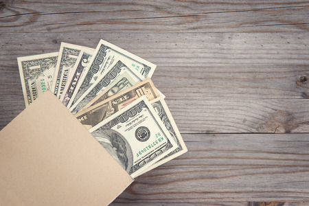 Bank notes on old wooden desk.の写真素材