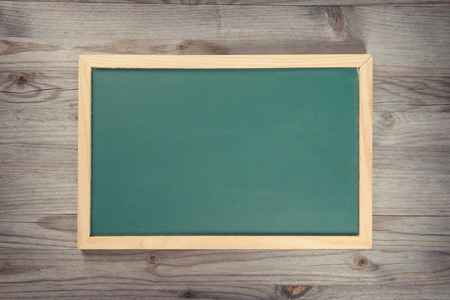 Empty blank green chalkboard with wooden frame on old wood backgroundの写真素材