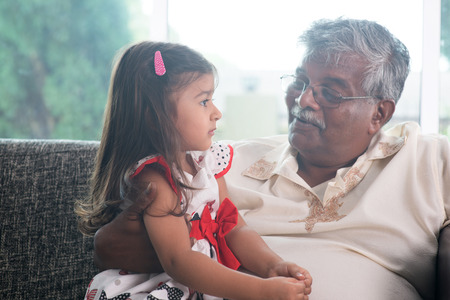 Portrait Indian family at home. Grandparent and grandchild talking together. Asian people living lifestyle. Grandfather and granddaughter.の写真素材