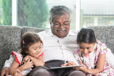  Grandparent and grandchildren using touch screen tablet computer.  の写真素材