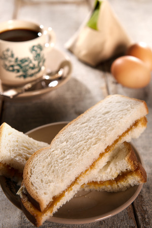Traditional oriental Chinese style breakfast and dark coffee in vintage mug and saucer. Fractal on the cup is generic print. Soft focus setting with dramatic ambient light on dark wooden background.の写真素材