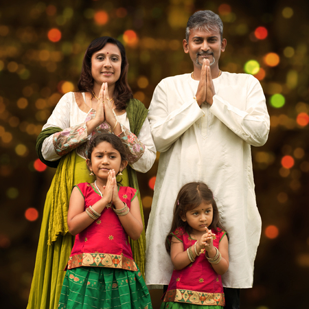 Indian family greeting on Diwali, festival of lights, inside a temple.の写真素材