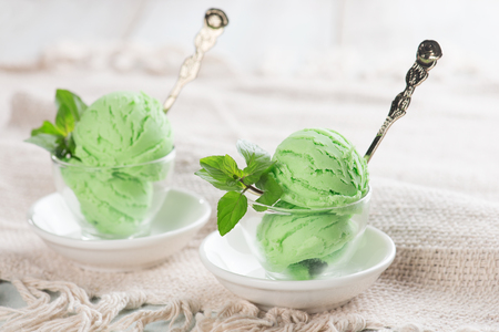 Scoop of honeydew ice cream in cup on wooden vintage background.の写真素材