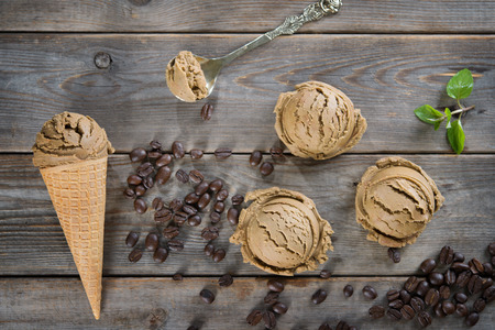 Top view mocha ice cream in waffle cone and coffee beans on old rustic vintage wooden background.の写真素材