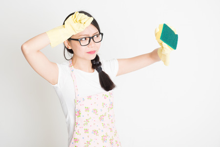 Young Asian housewife with sponge scrubbing dirt.の写真素材