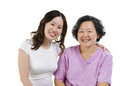 Portrait of Asian senior mother and adult daughter smiling and looking at camera, isolated on white background.の写真素材