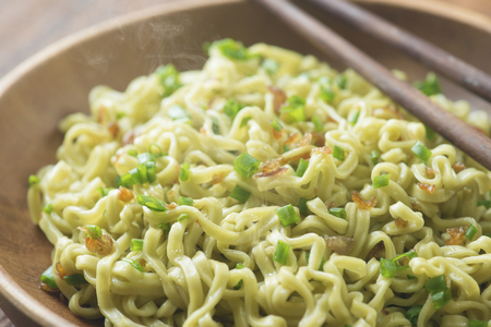 Close up Japanese ramen dried noodles with chopsticks on rustic wooden table.の写真素材