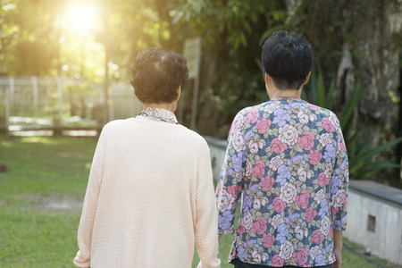 Candid shot of rear view Asian old women walking at outdoor park in the morning.の写真素材