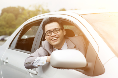 Happy driver sitting in his car and smiling.の写真素材