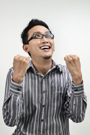 Asian businessman looking up celebrating success.の写真素材