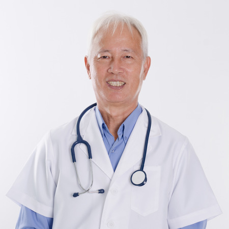 Portrait of confident Asian medical doctor smiling, standing isolated on white background.の写真素材