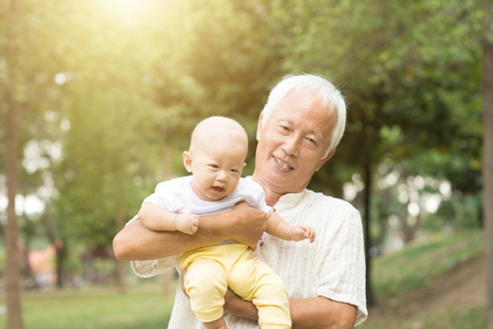 Grandfather with baby grandson at outdoor park, Asian family.の写真素材