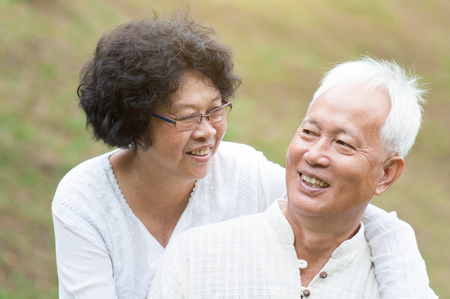 Portrait of mature Asian couple relaxing at outdoor park.の写真素材