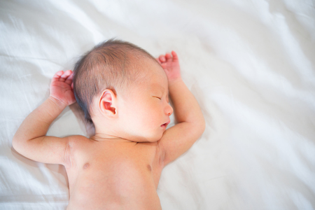 Asian newborn baby boy sleeping with tenderness in white blanket, 7 days old.の写真素材