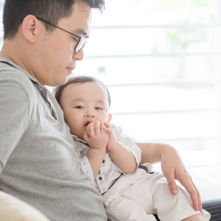 Asian family at home. Father holding baby boy, living lifestyle indoors. の写真素材
