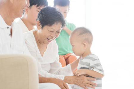 Happy Asian family relaxing at home, candid moment of multi generations people indoor lifestyle.の写真素材