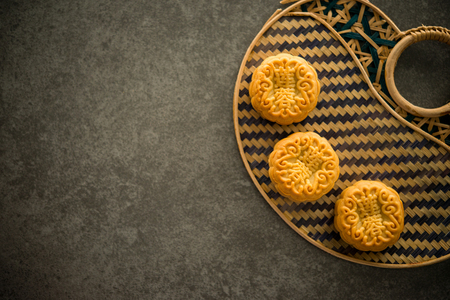 Traditional pastry mooncakes is offered to friends or family during Mid-Autumn Festival. Flatlay table top view dark light with copy space. The Chinese character on the moon cake represent "lotus paste" in English.の写真素材