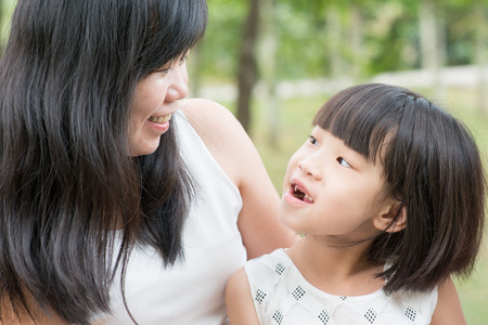 Happy mother and daughter bonding at green park. Asian family outdoors activity.の写真素材