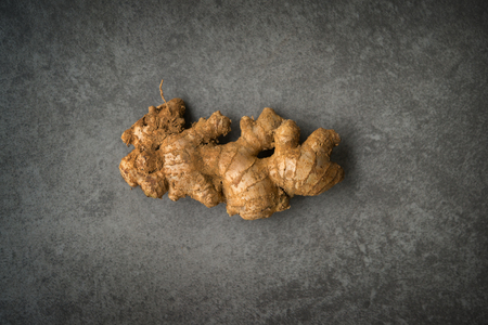 Top view fresh raw ginger root with copy space on dark background.の写真素材